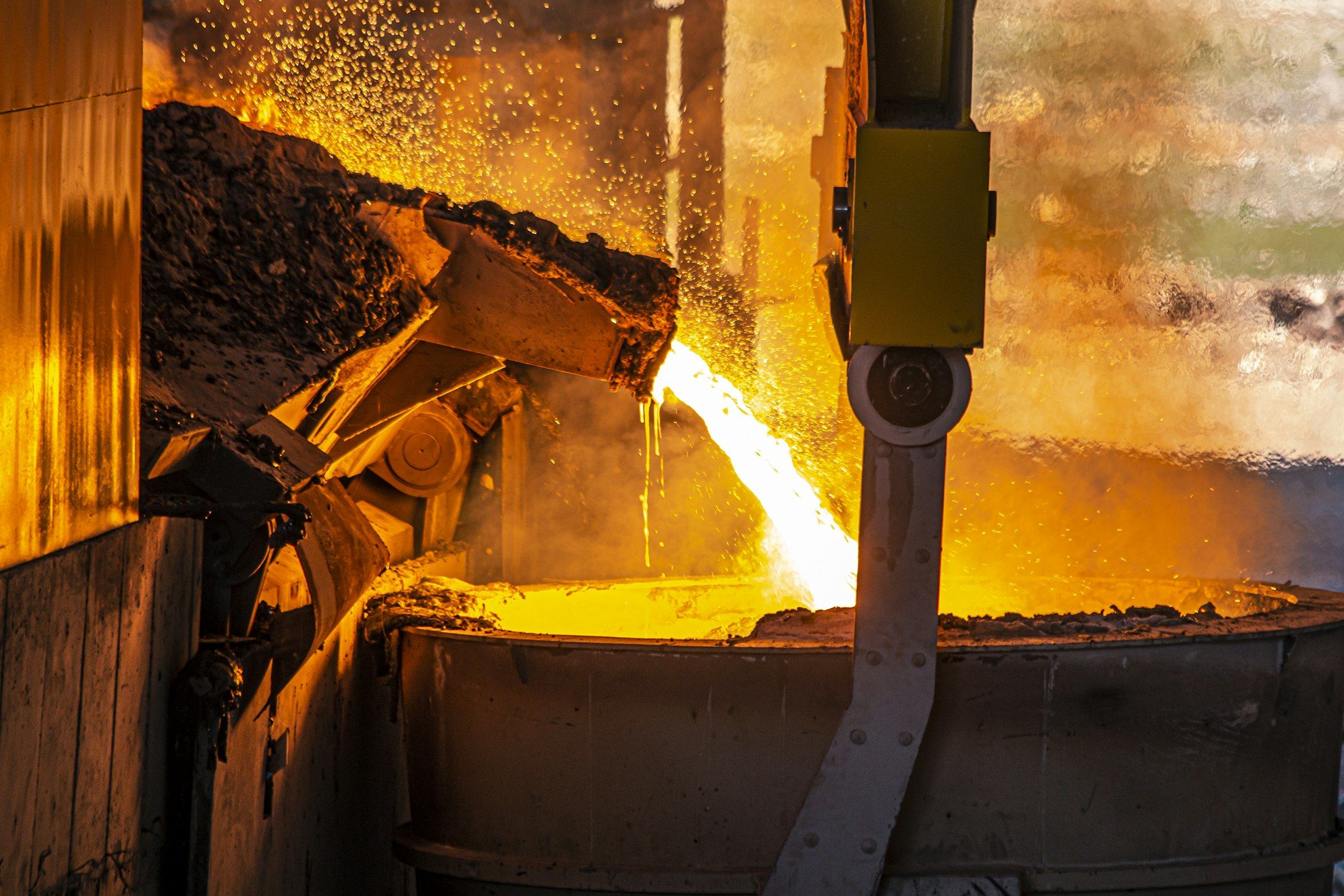 Molten metal pouring from a furnace into an industrial ladle