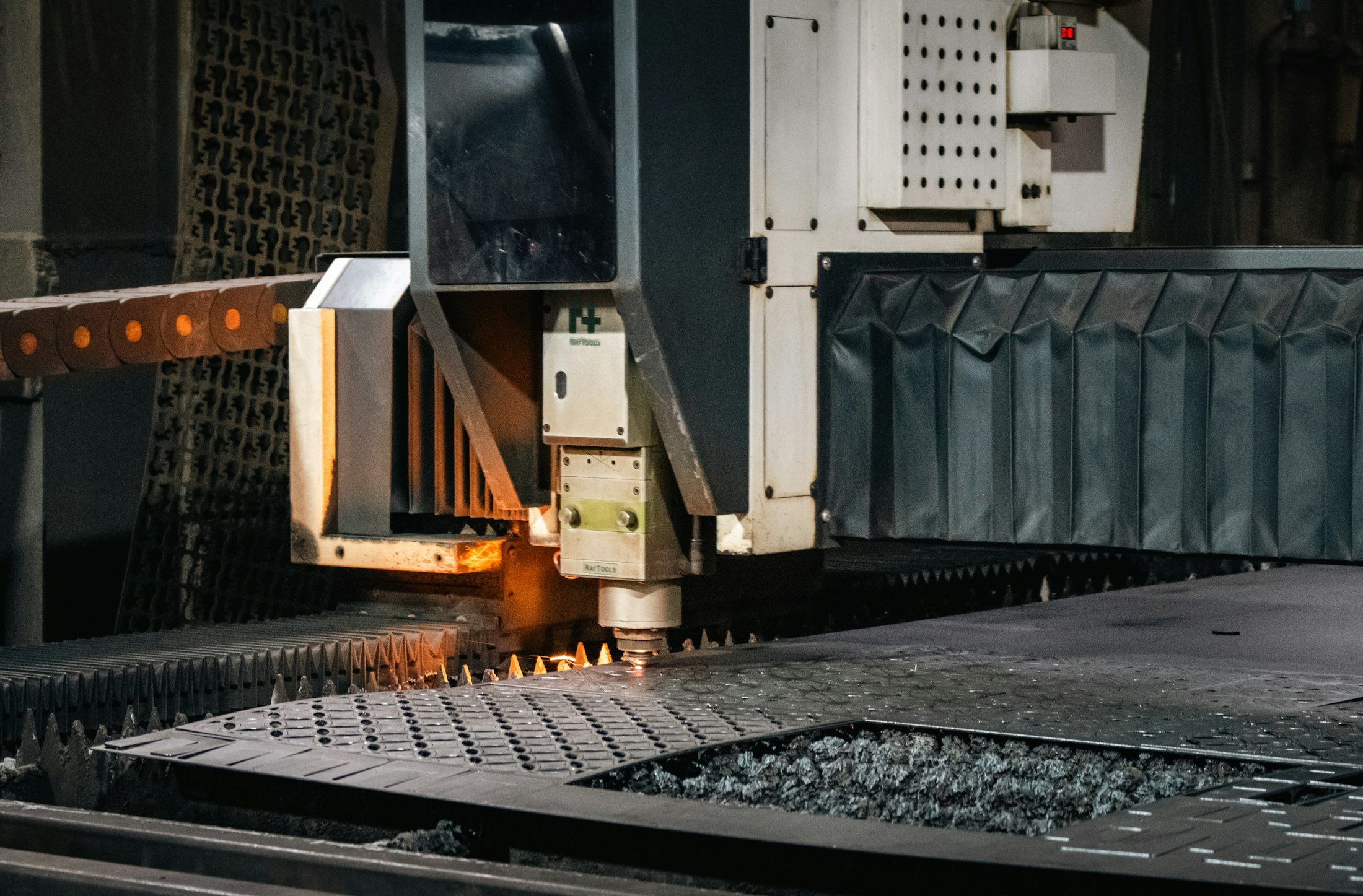 Ein industrieller Laserschneider bearbeitet ein Blech