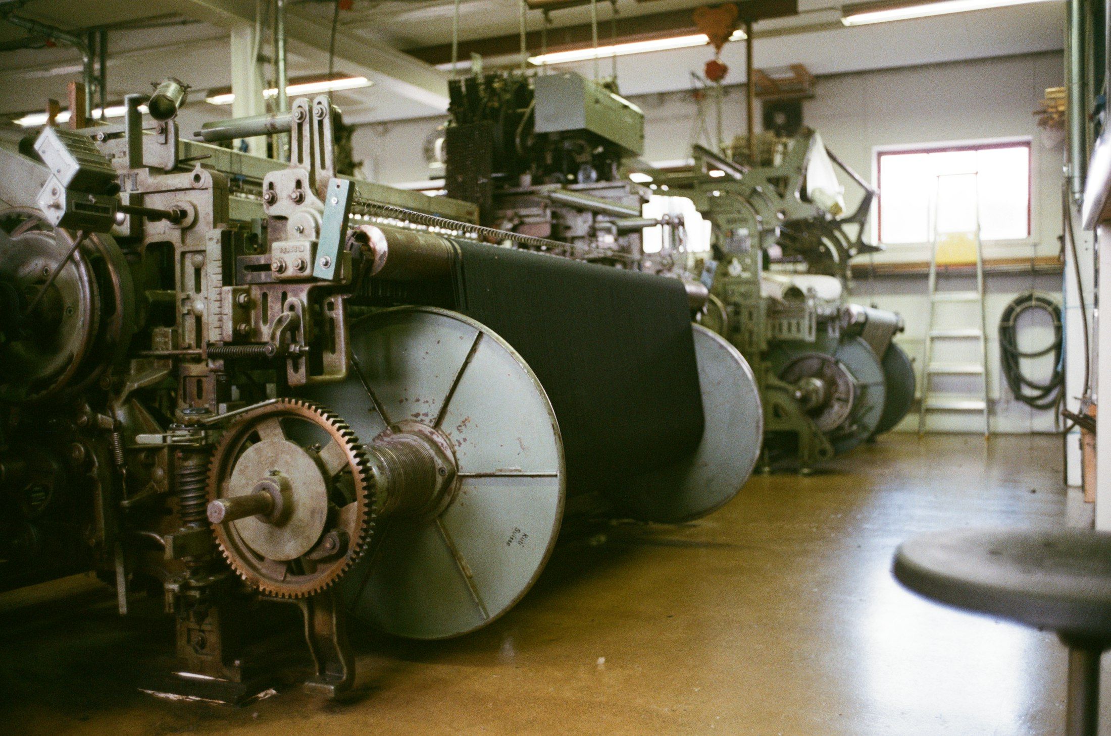 A row of industrial weaving looms in a textile workshop