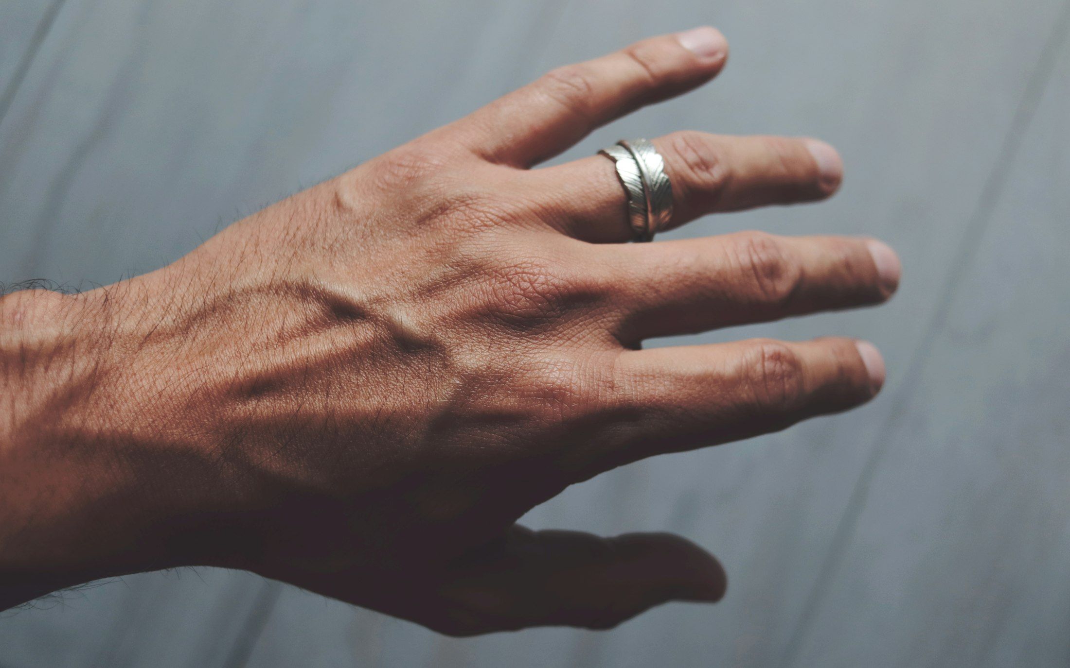 Eine Männerhand mit einem schlichten Ring aus Sterlingsilber