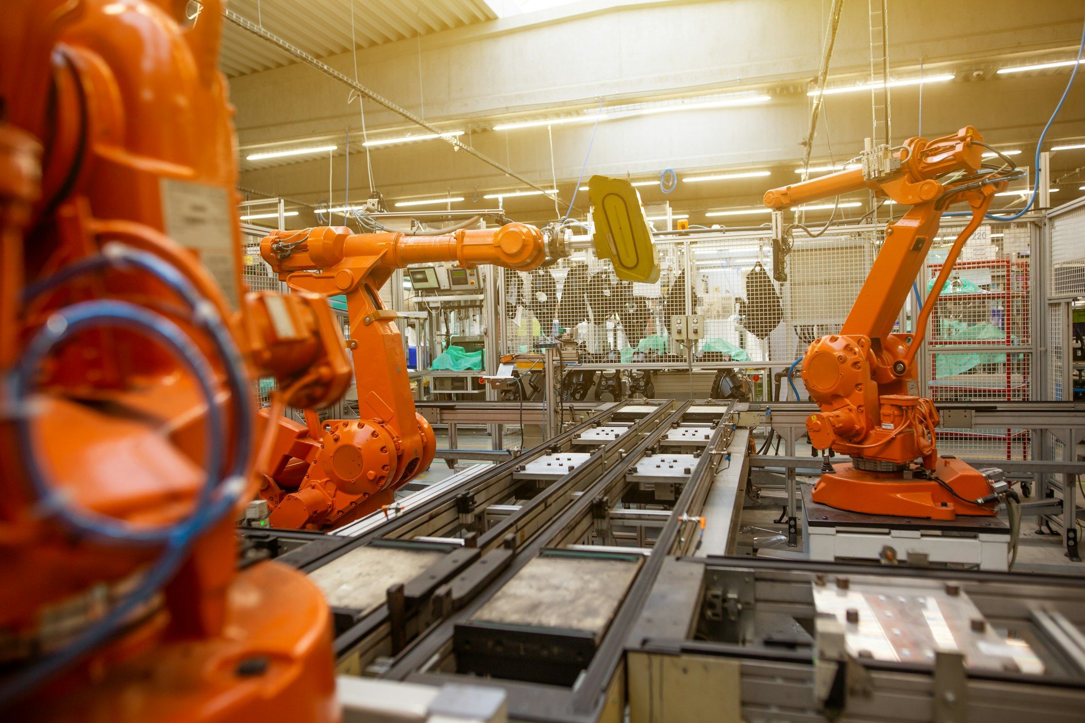 Eine Produktionshalle mit Reihen orangefarbener Industrieroboter