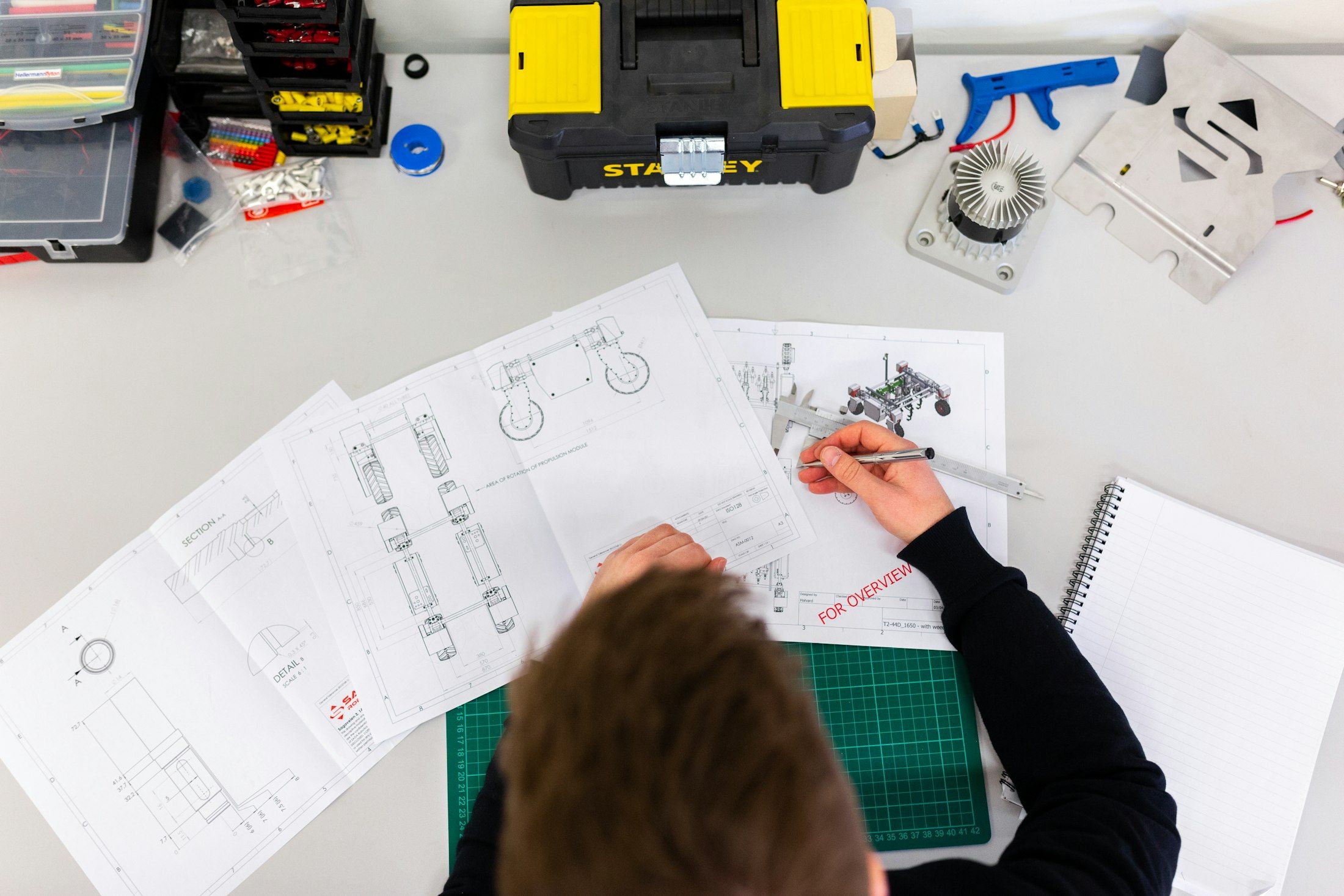 Ein Ingenieur misst technische Zeichnungen mit einem Messschieber